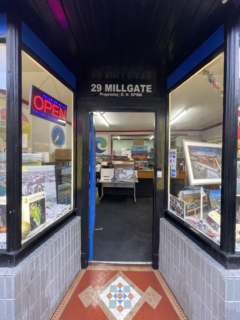 a picture of a shop door with windows either side